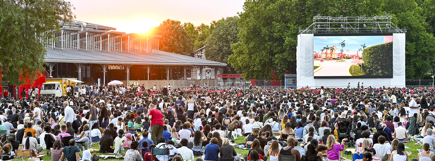 Spectateurs installés sur l’herbe pour une séance de cinéma sous les étoiles à Paris
